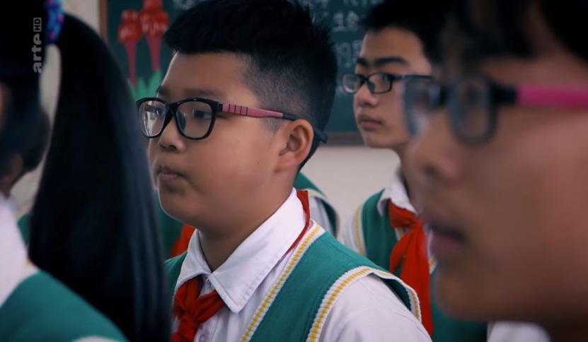 Schulkinder mit Brillen in Sitzreihen