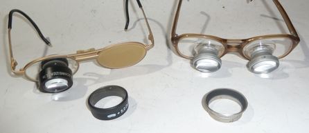 2 Fernrohrlupenbrillen (Lupenaufsteckgläser liegen davor)